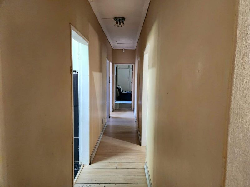 A functional hallway featuring wooden flooring and multiple doorways, providing access to various rooms within the home.