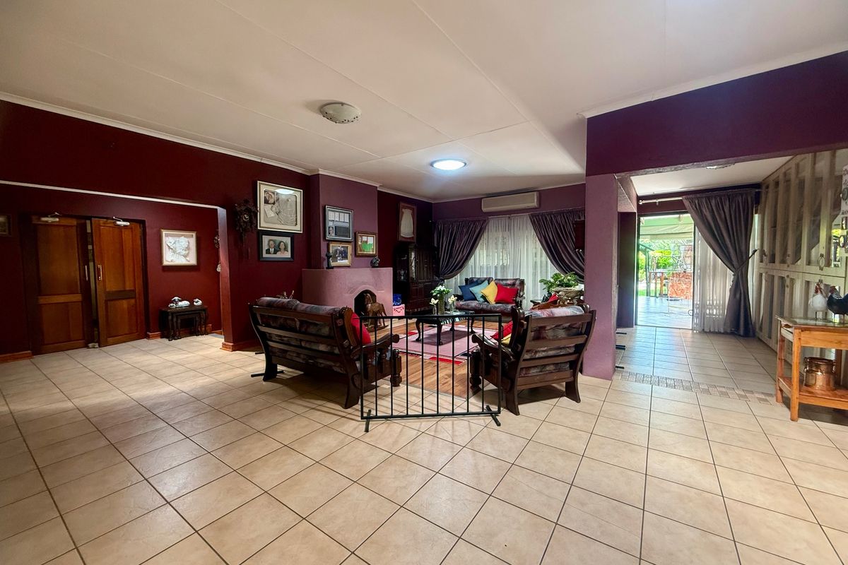Spacious living area featuring tiled flooring, a central fireplace, and direct access to the outdoor patio through sliding glass doors.