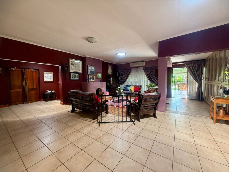 Spacious living area featuring tiled flooring, a central fireplace, and direct access to the outdoor patio through sliding glass doors.