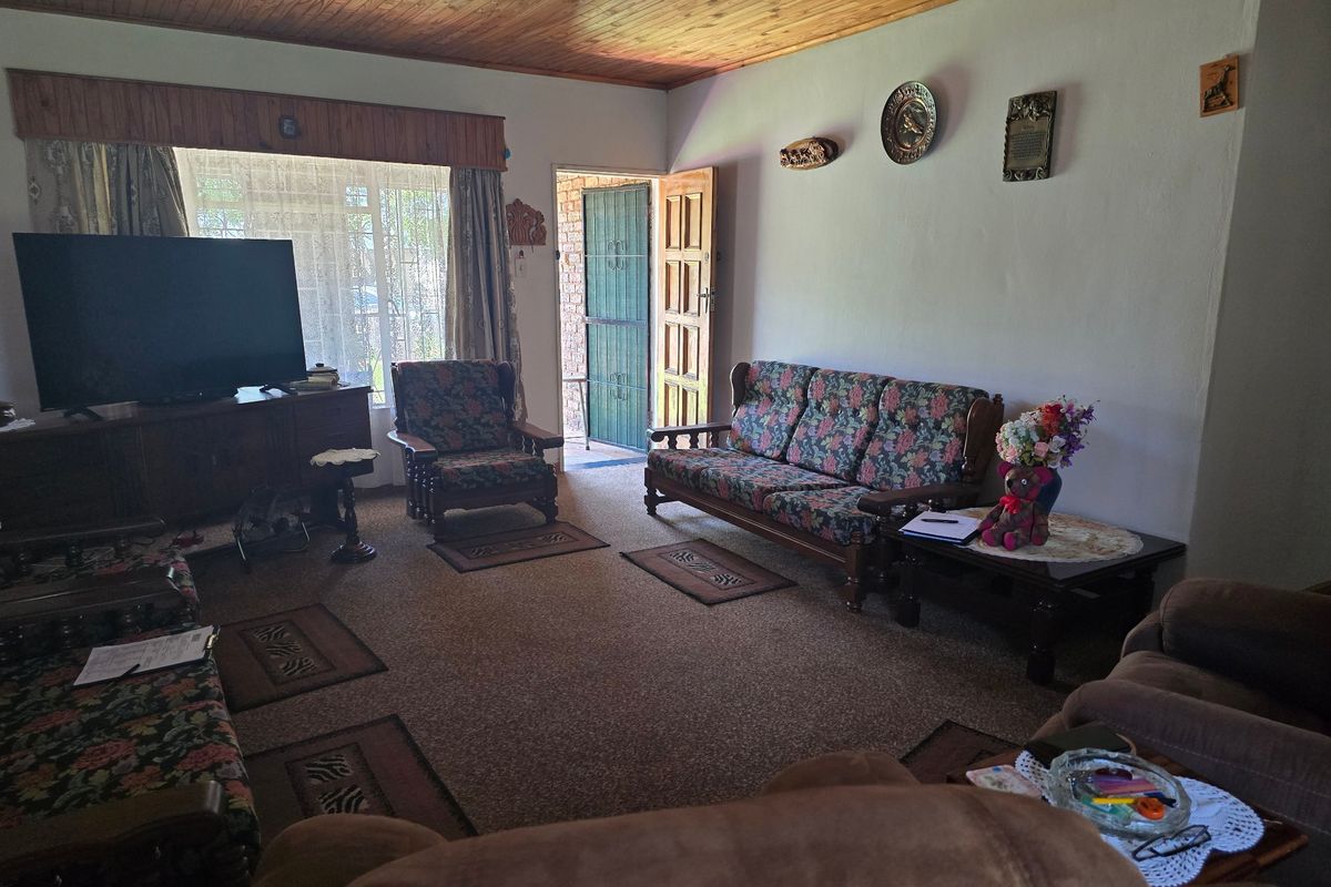 A living room featuring a timber tongue and groove ceiling and direct access to the exterior via a security gate.
