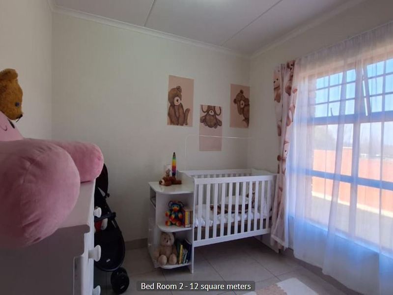 A 12 square meter bedroom featuring tiled flooring and a large window, providing natural light and a functional space for a nursery or bedroom.