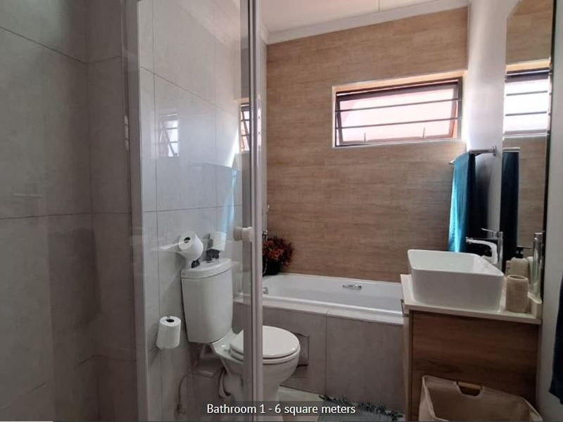 Modern bathroom featuring a shower enclosure, built-in bathtub, vanity with vessel sink, and contemporary wall tiling.
