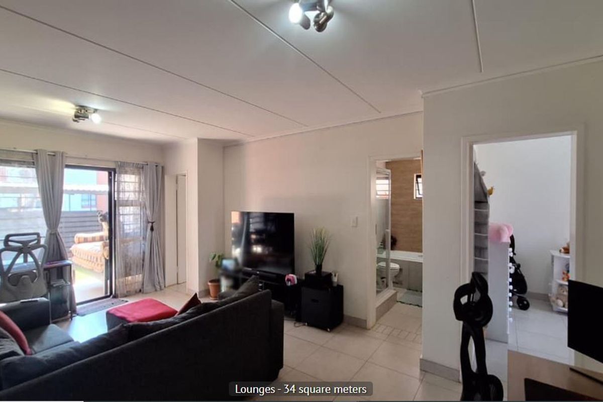 Spacious living area featuring tiled flooring and a large sliding glass door providing access to the outdoor space.