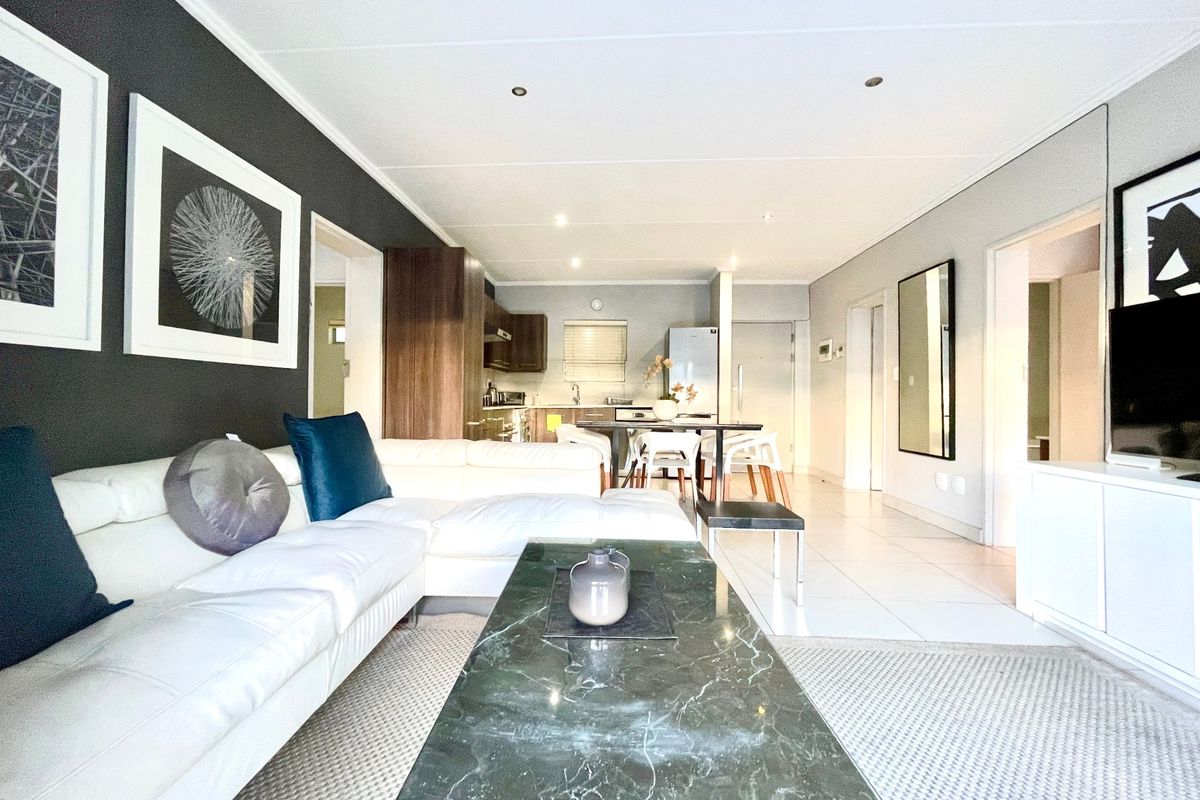 Spacious open-plan living and dining area featuring modern tiled flooring, recessed lighting, and a seamless transition into the functional kitchen space.