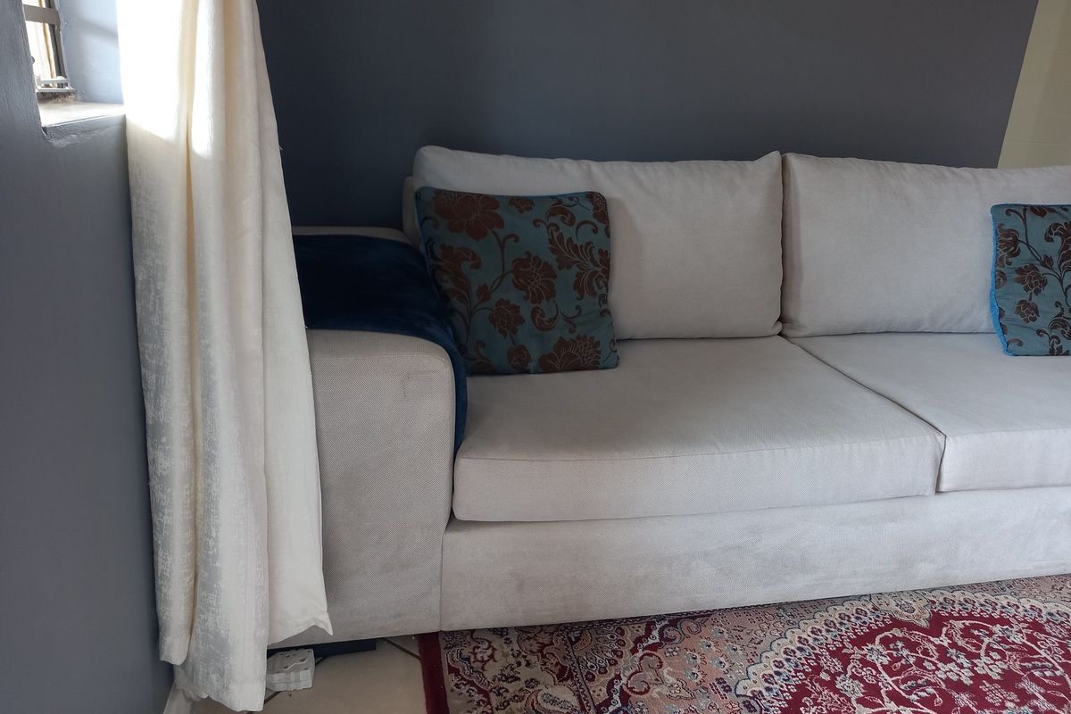 A living room area featuring tiled flooring and neutral painted walls, providing a functional space for relaxation.