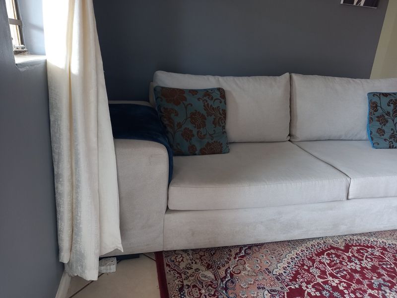A living room area featuring tiled flooring and neutral painted walls, providing a functional space for relaxation.