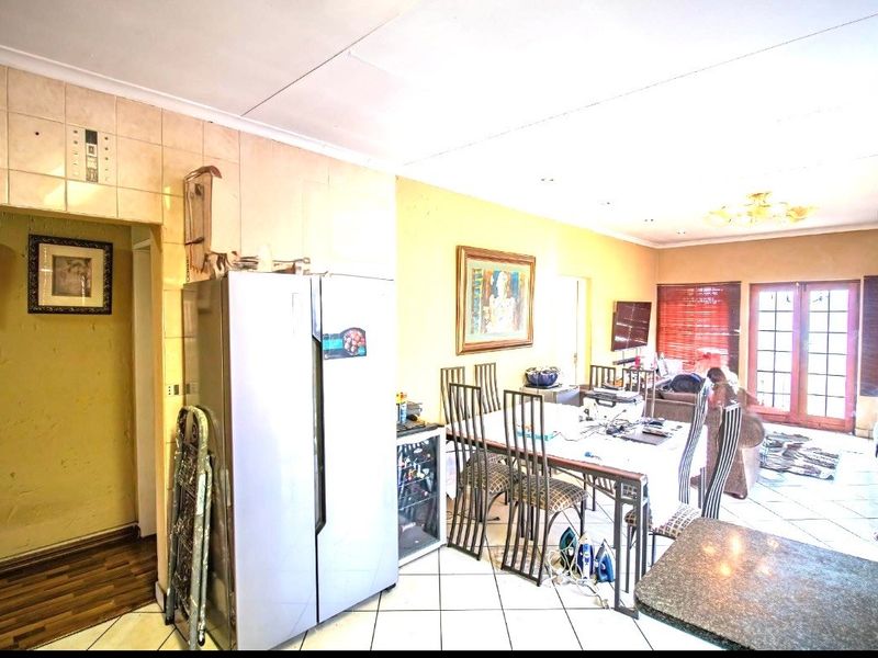 Open-plan living and dining area featuring tiled flooring and direct access to the outdoors through french doors.