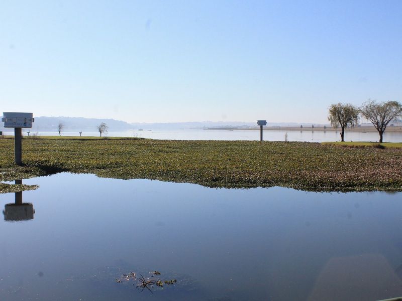 A scenic view of a lakefront property featuring calm water and natural vegetation.