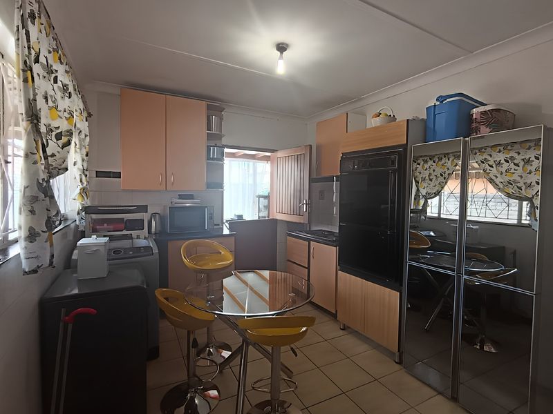 A functional kitchen featuring built-in cabinetry, a built-in oven, and tiled flooring, offering a practical layout with potential for modern updates.