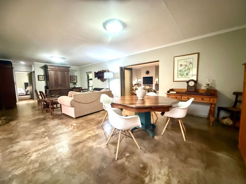 Spacious open-plan living and dining area featuring polished concrete flooring and neutral wall finishes, providing a versatile layout for modern living.