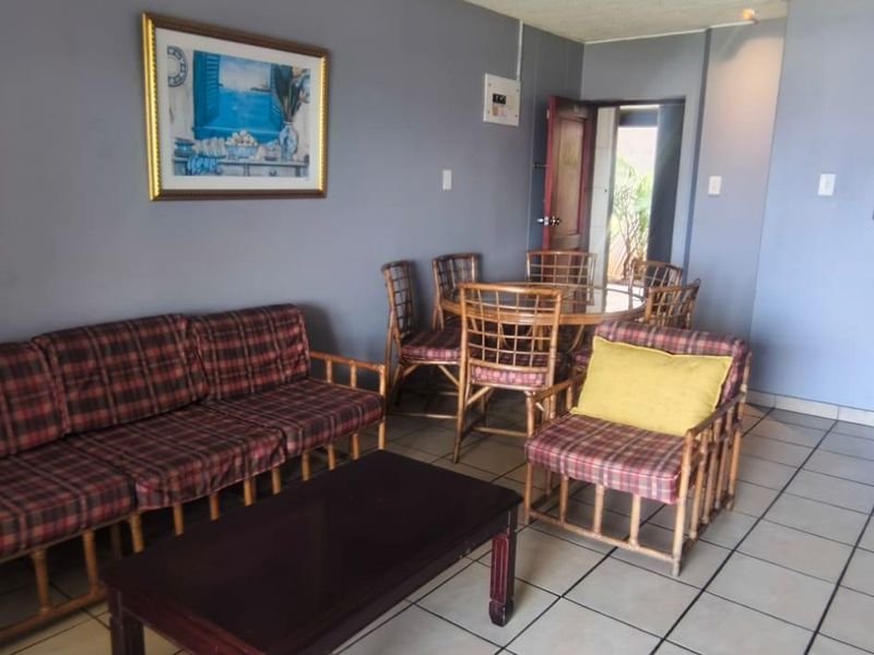 Open plan living and dining area featuring tiled flooring and neutral wall finishes, providing a functional space for relaxation and meals.