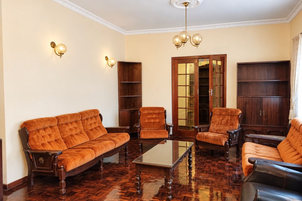 A traditional living room featuring polished parquet flooring, crown molding, a decorative ceiling rose, and built-in wooden shelving units.