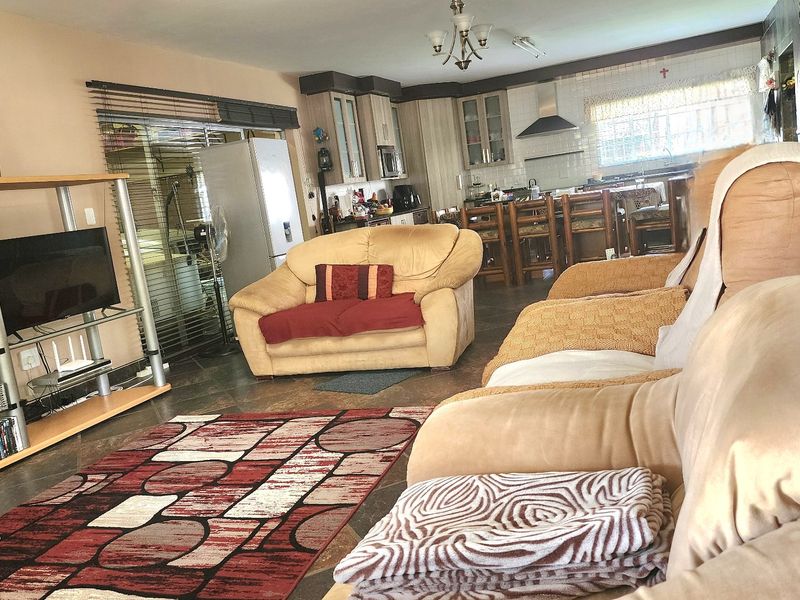 Spacious open-plan living area featuring tiled floors and a functional kitchen with built-in cabinetry and a central island.