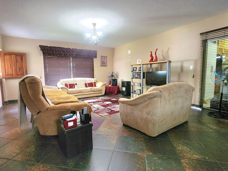 Spacious living room featuring durable slate tile flooring and a large sliding glass door providing access to the exterior.