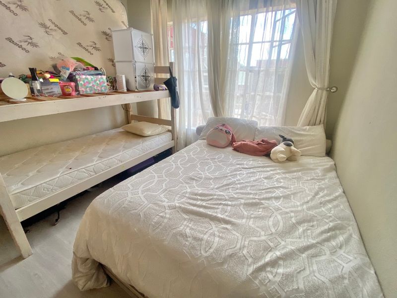 A bedroom featuring natural light from a large window, providing a functional space for rest.