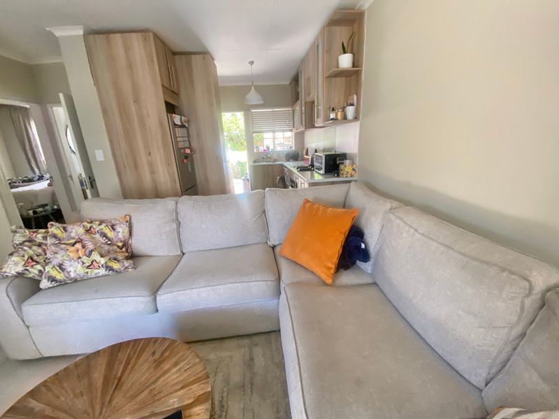 Open-plan living area featuring a modern kitchen with light wood cabinetry and a seamless flow into the lounge space.