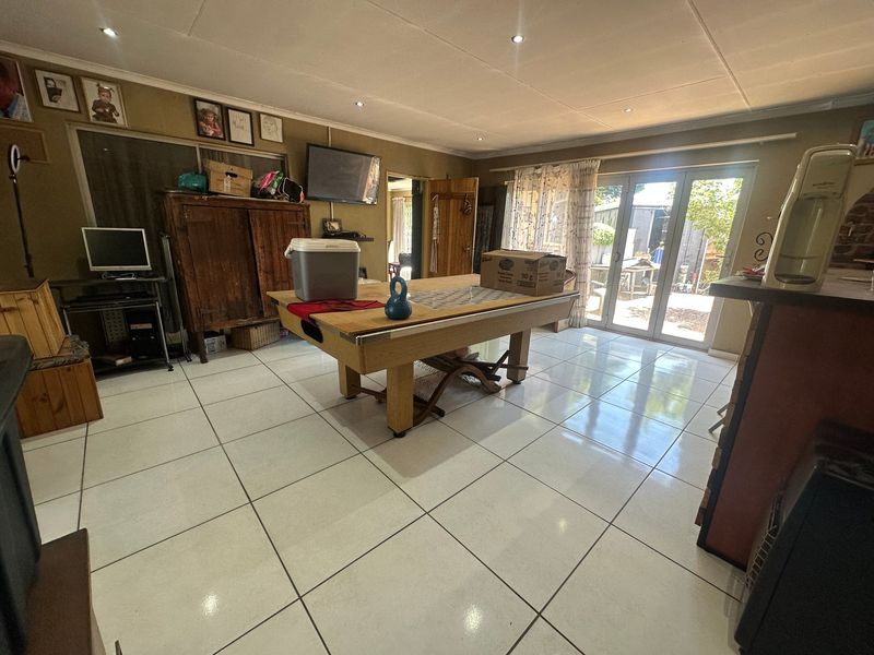 Spacious living area featuring large format floor tiles, recessed lighting, and sliding glass doors providing direct access to the outdoor patio area.