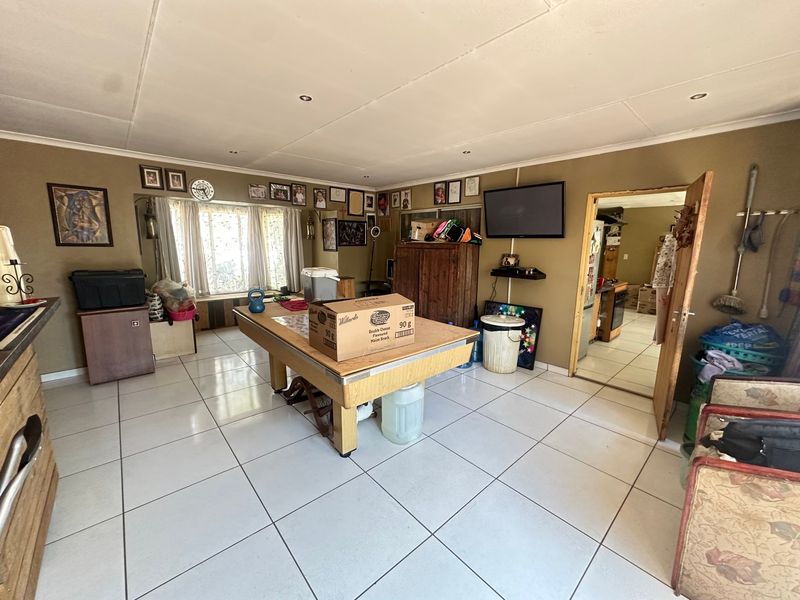 Spacious living area featuring tiled flooring, recessed ceiling lights, and a built-in window seat, offering a versatile layout for family living.