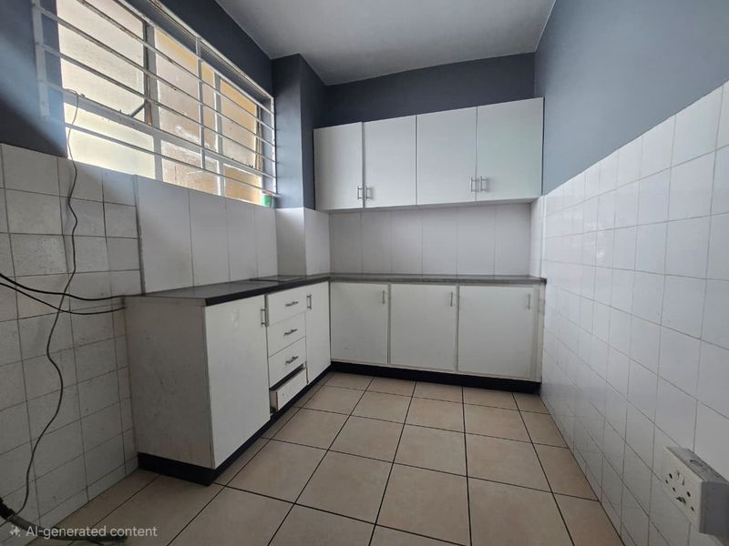 A functional kitchen space featuring white built-in cabinetry, tiled splashbacks, and tiled flooring, ready for personalization or modern updates.