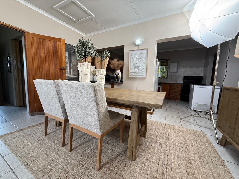 Open plan dining area featuring tiled flooring and a view into the adjacent kitchen space.