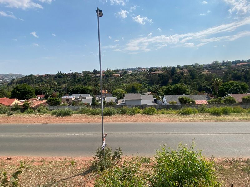 A street-level view of the residential area showing the paved road, street lighting, and surrounding neighborhood landscape.