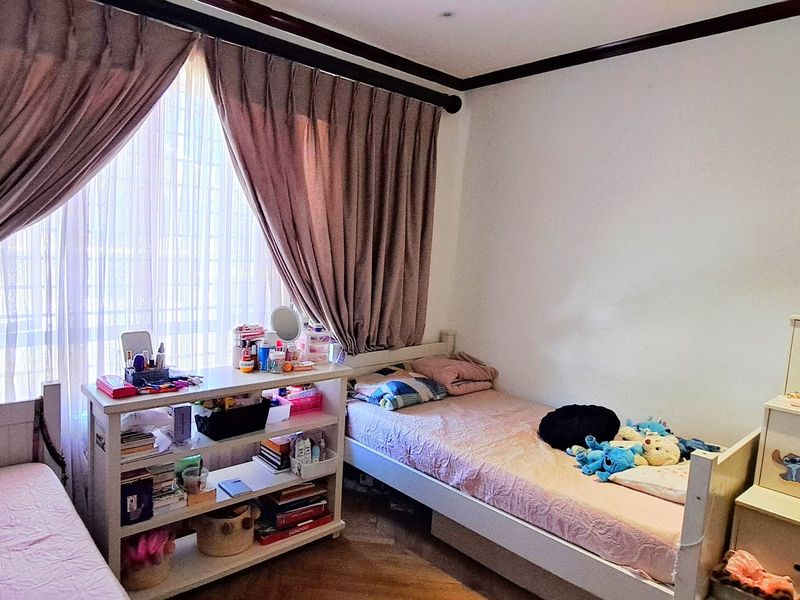 A bedroom featuring large windows with curtains, crown molding, and recessed lighting, providing a functional space with natural light.