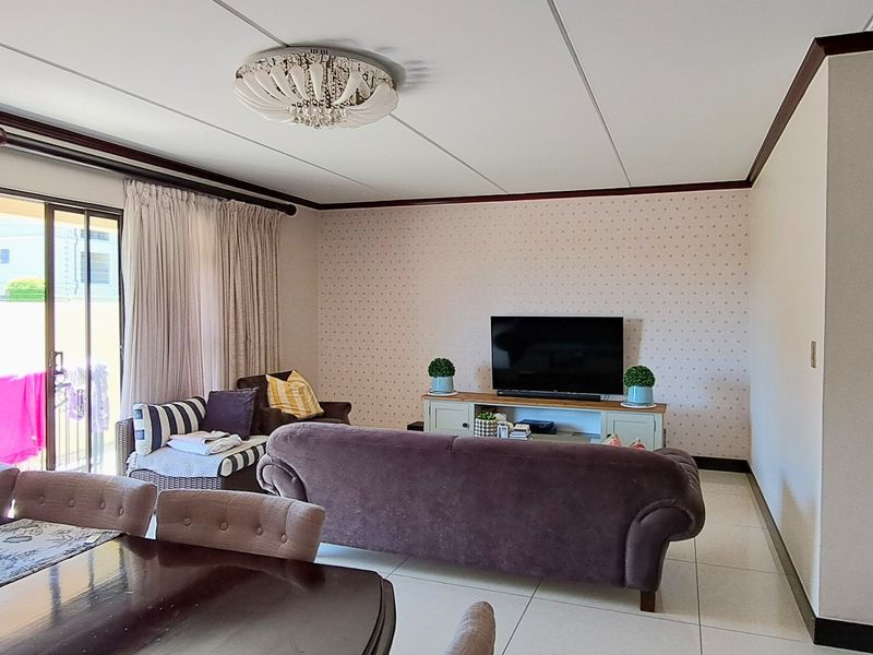 Open plan living and dining area featuring tiled flooring and a sliding glass door leading to an outdoor space.