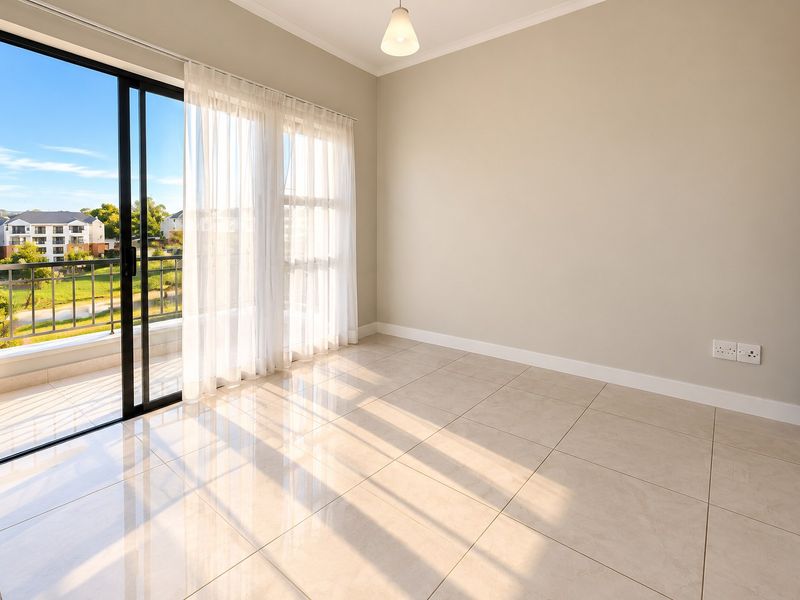 A bright, empty bedroom featuring neutral tiled flooring, a modern ceiling light, and a large sliding glass door leading to a private balcony.