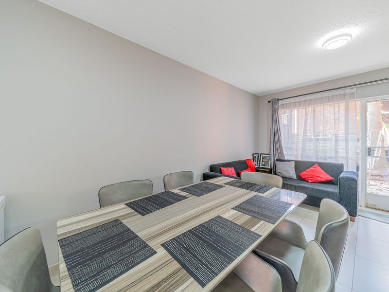 Open plan living and dining area featuring tiled flooring and a sliding glass door providing access to the exterior.