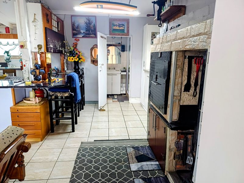 Open plan living area featuring a built-in fireplace, tiled flooring, and a breakfast bar, with direct access to an adjacent bathroom.