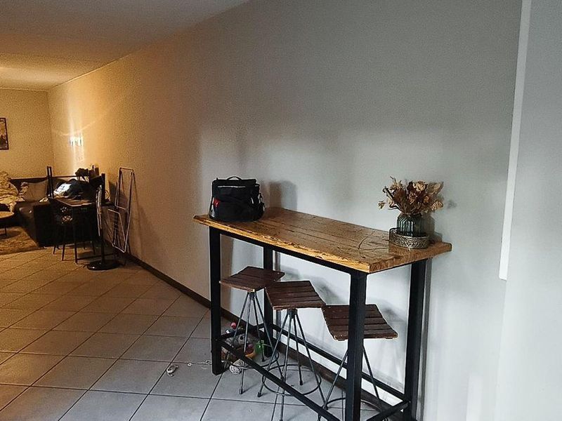 Spacious living area featuring tiled flooring and a built-in fireplace, offering a versatile layout for comfortable daily living.