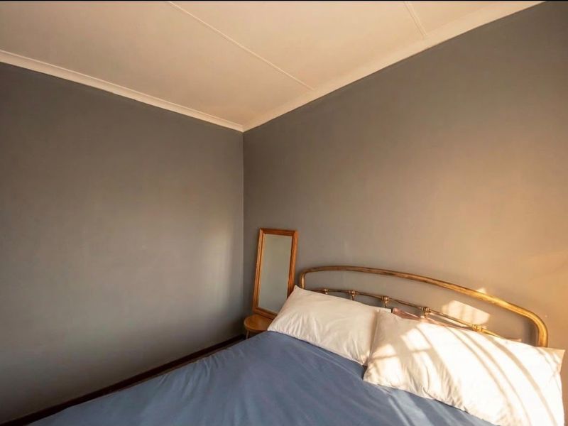 A bedroom featuring grey painted walls and decorative cove cornicing, providing a neutral foundation for interior design.