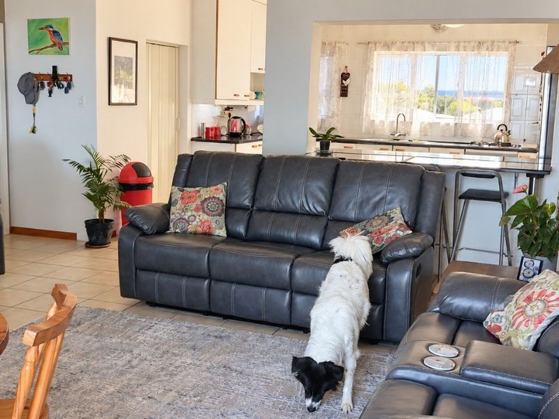 Open plan living area featuring a connected kitchen with breakfast bar and tiled flooring, creating a functional and integrated space for daily living.