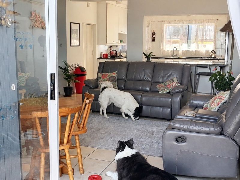 Open plan living and kitchen area featuring tiled flooring and direct access to the patio through a sliding glass door.