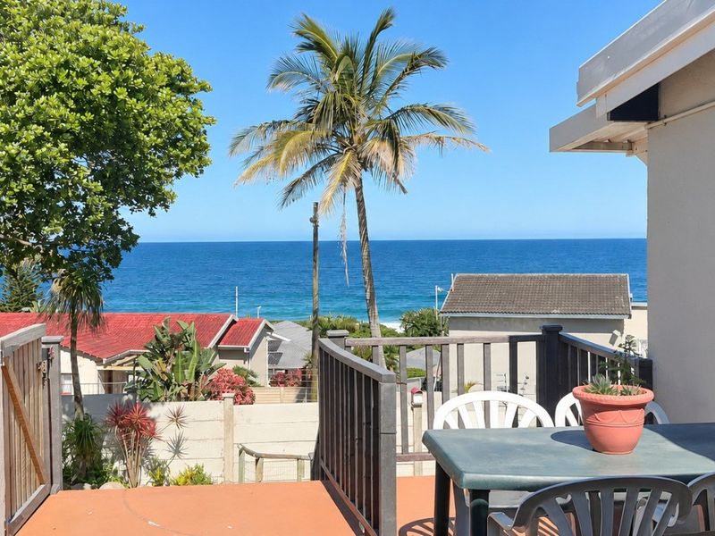 An elevated balcony area featuring a railing and offering expansive ocean views.