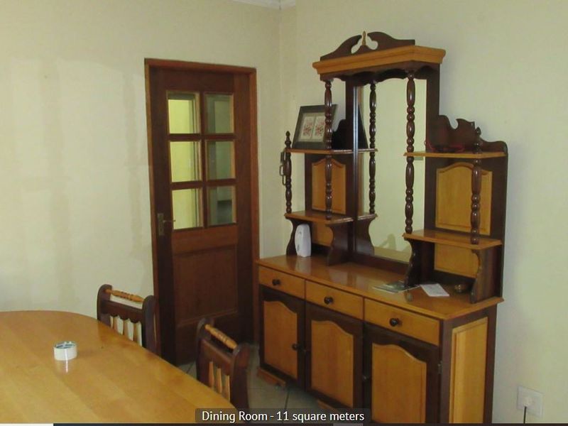 A dining room featuring tiled flooring and a traditional wooden door with glass panels.