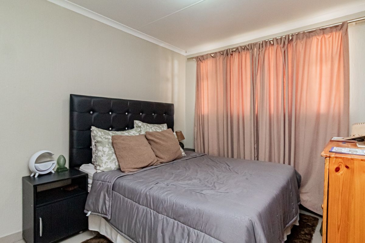 A standard bedroom featuring neutral wall finishes, coving, and a window fitted with a curtain rod.