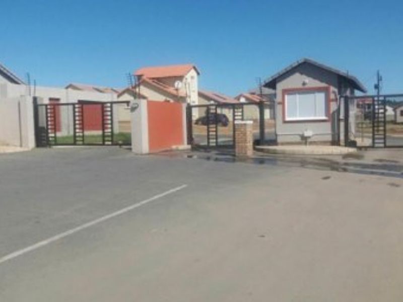 The entrance to the residential estate features a secure gated access point with a guard house and perimeter electric fencing.