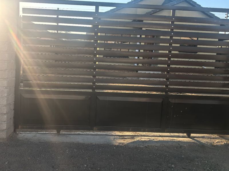 A modern horizontal slat metal sliding gate providing secure access to the property frontage.