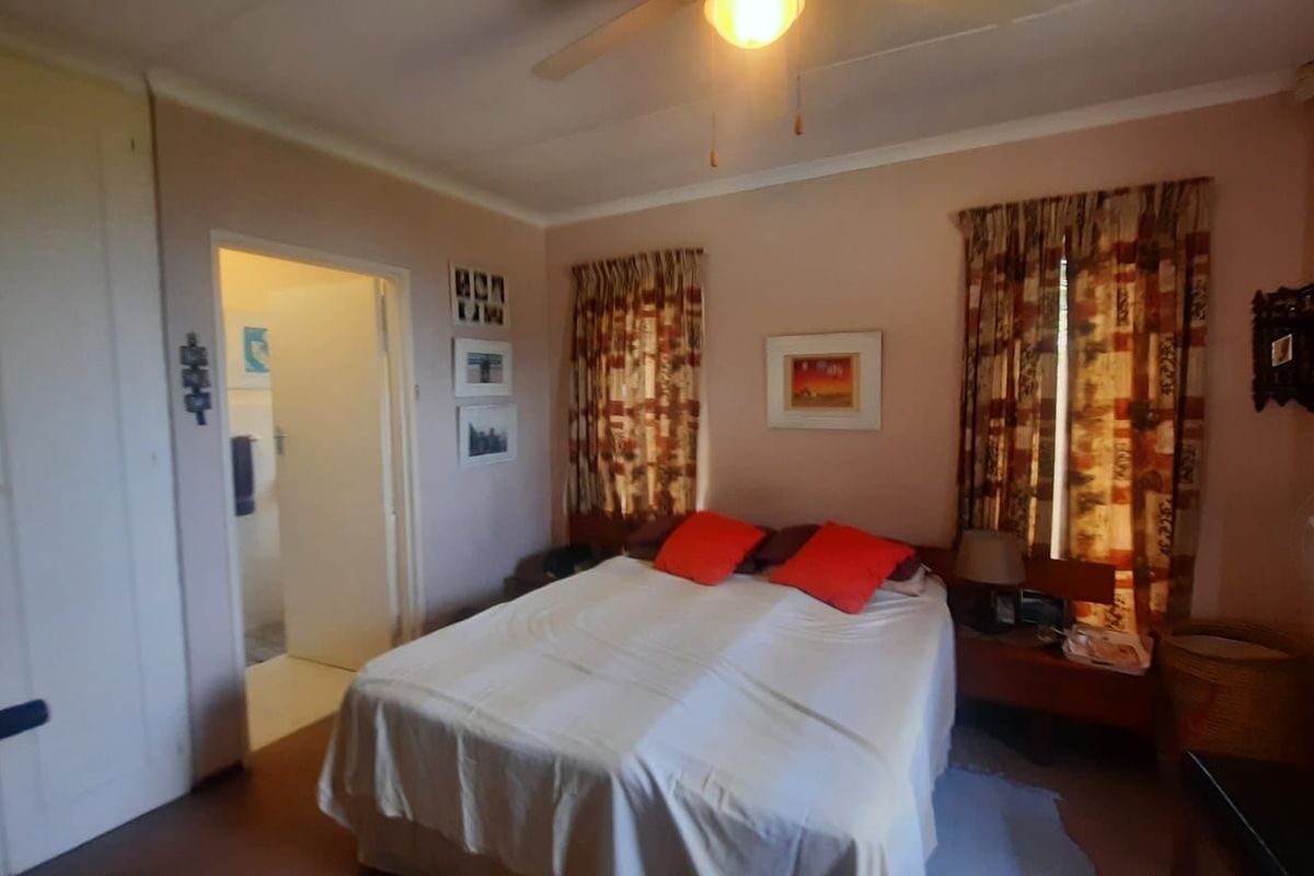 A bedroom featuring a built-in wardrobe, ceiling fan, and direct access to an en-suite bathroom.