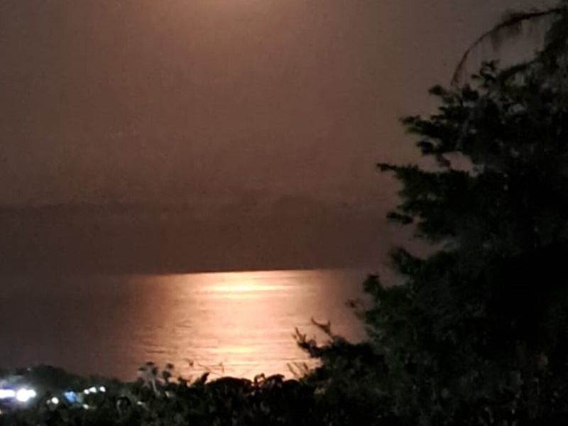 A night-time view of the ocean and coastline from an elevated position.