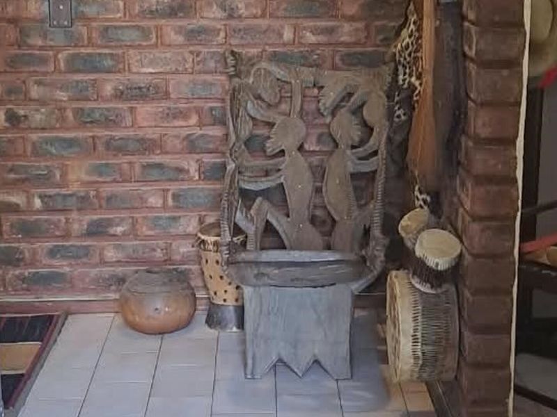 An entrance area featuring exposed brick walls and ceramic floor tiles, providing a rustic and textured aesthetic to the home's foyer.
