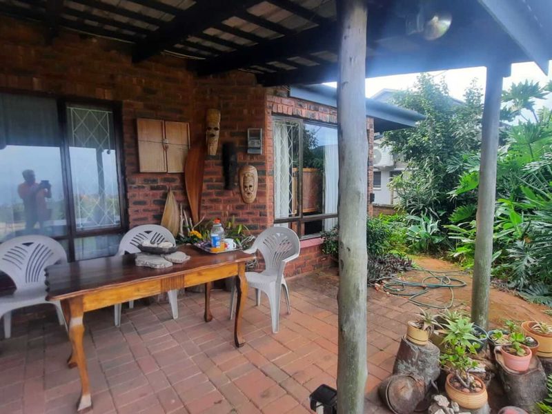 A covered outdoor patio area featuring face brick walls, timber support posts, and brick paving, providing a functional space for outdoor relaxation.