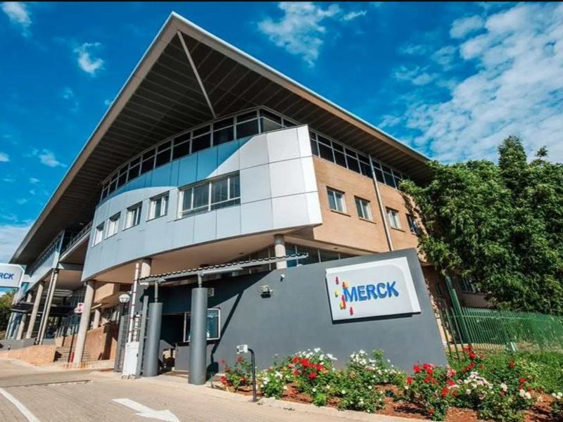 A modern commercial office building featuring a prominent pitched roof, metal and glass facade, and professional exterior signage.