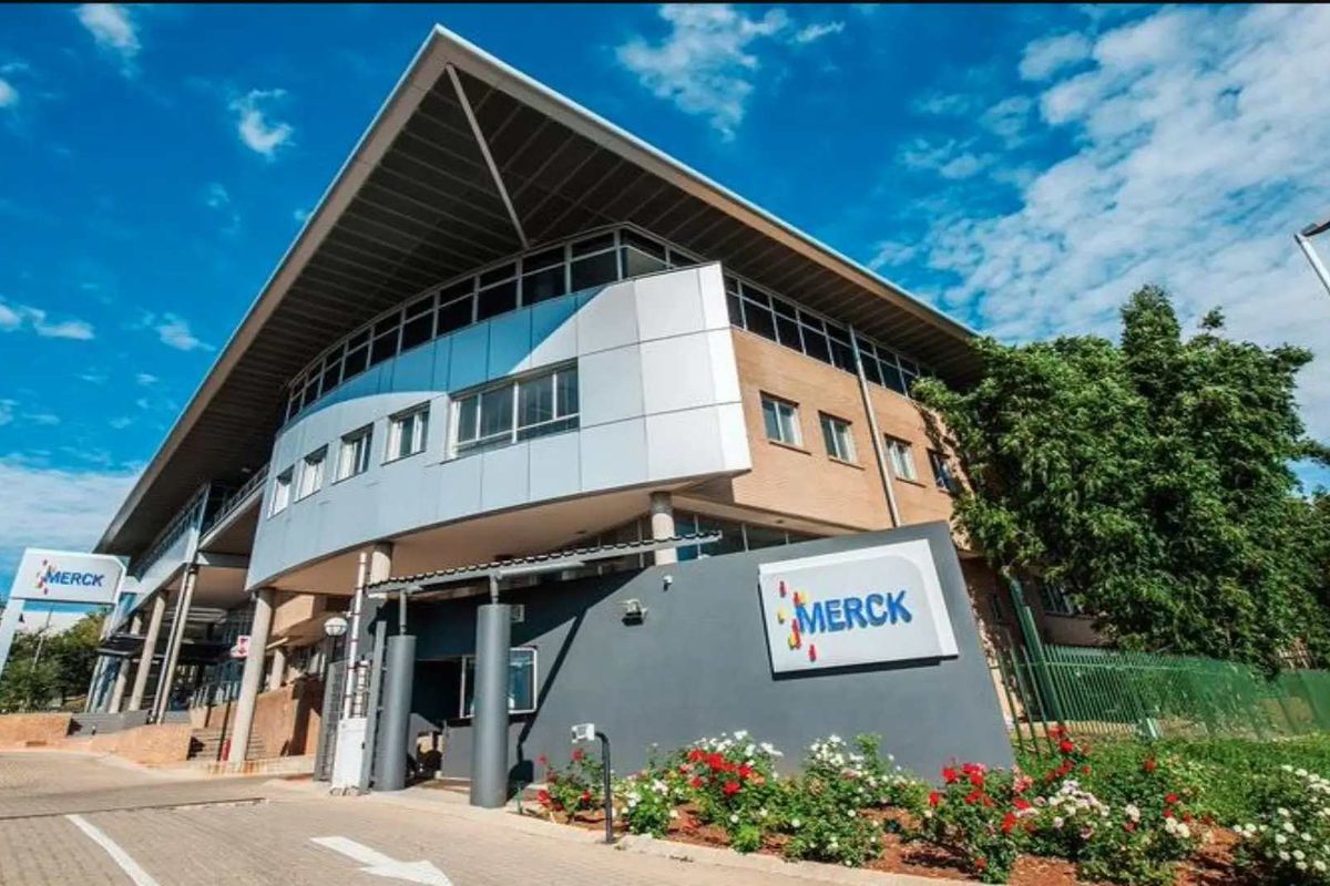 A modern commercial office building featuring a prominent pitched roof, metal and glass facade, and professional exterior signage.