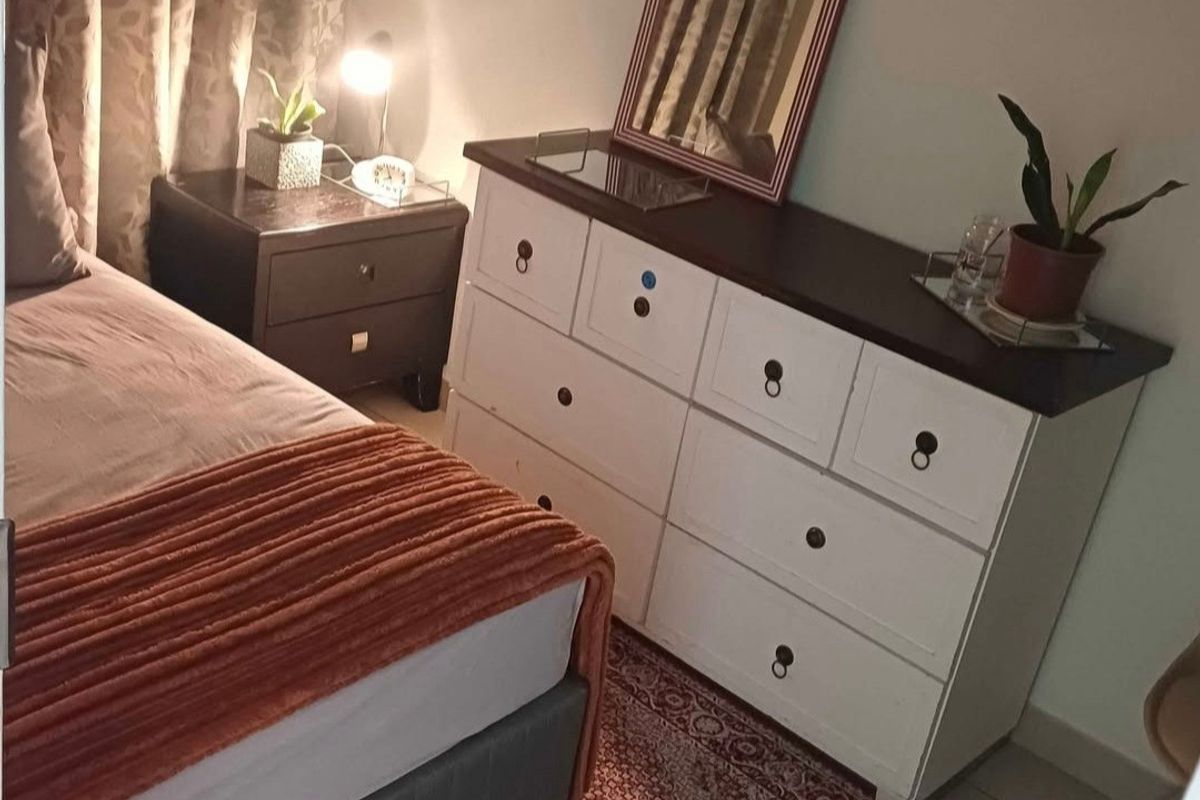 A bedroom featuring tiled flooring and neutral wall finishes, providing a functional sleeping space.