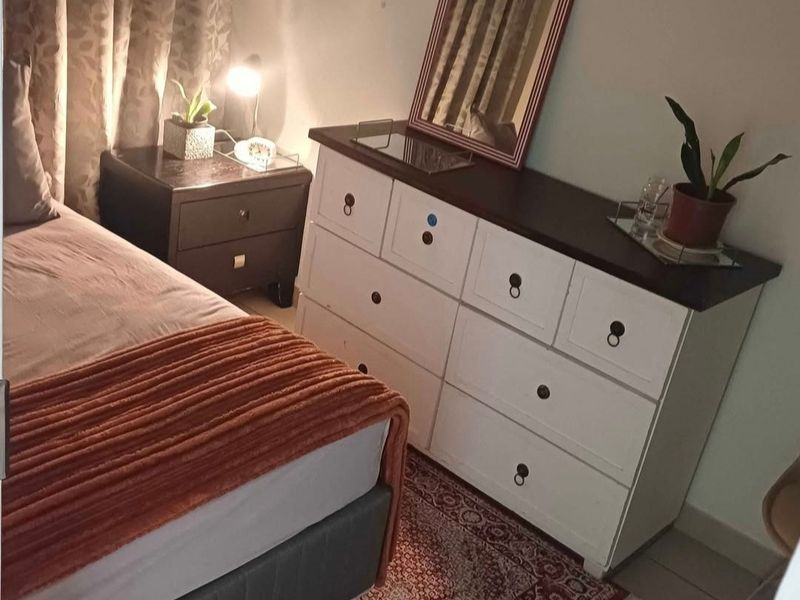 A bedroom featuring tiled flooring and neutral wall finishes, providing a functional sleeping space.