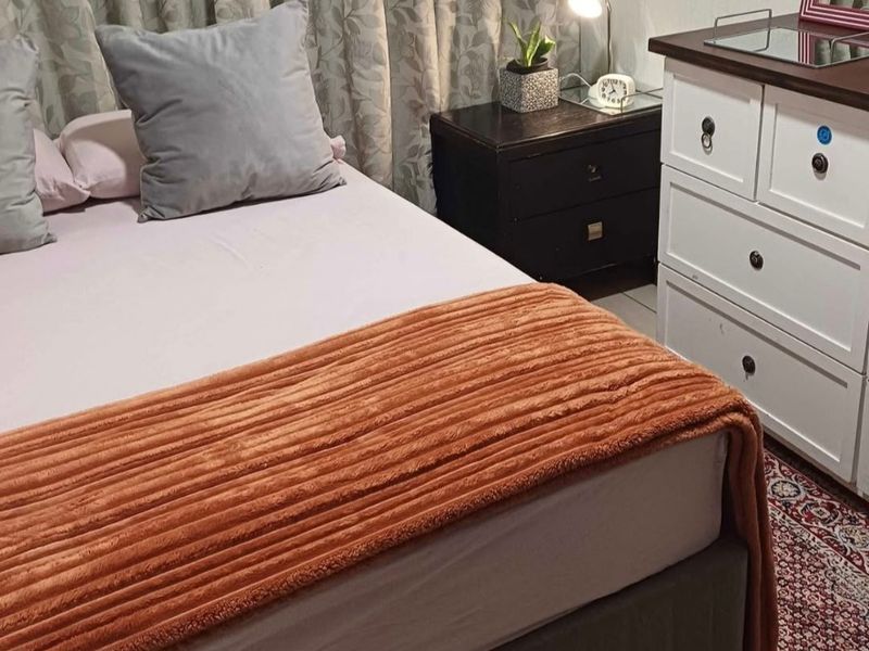 A bedroom interior featuring standard finishes, curtains, and tiled flooring.