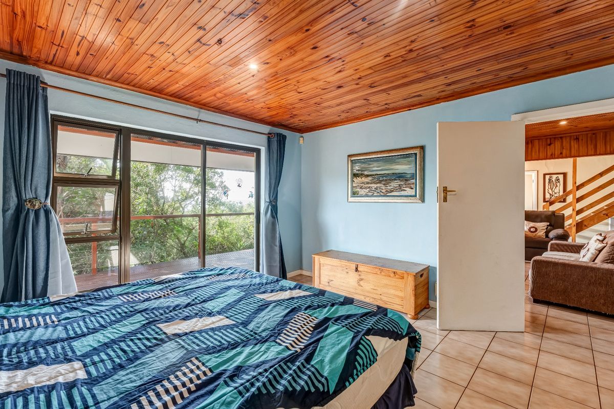 Bedroom featuring a warm timber tongue and groove ceiling, tiled flooring, and a sliding glass door providing access to an outdoor deck area.