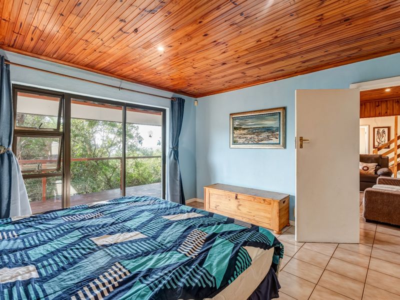 Bedroom featuring a warm timber tongue and groove ceiling, tiled flooring, and a sliding glass door providing access to an outdoor deck area.